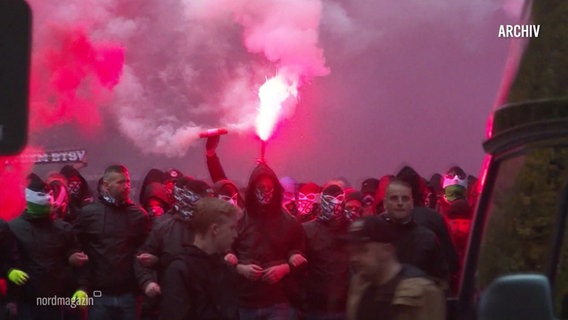 Fußballfans halten Pyrotechnik in den Händen. © Screenshot 