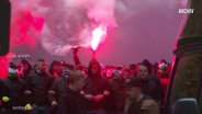 Fußballfans halten Pyrotechnik in den Händen. © Screenshot 