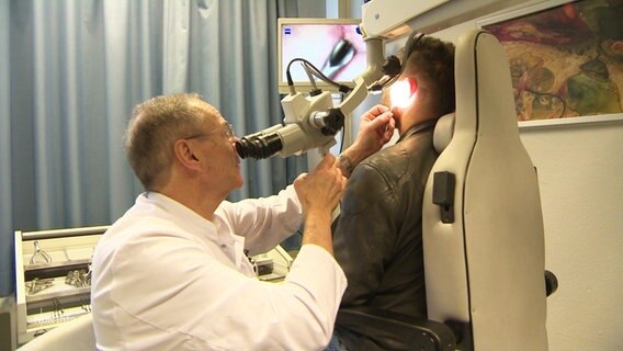 Ein HNO-Arzt untersucht das Ohr eines Patienten. © Screenshot 