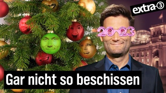 Christian Ehring mit einer rosaroten 2023-Brille neben einem geschmückten Weihnachtsbaum. Wie geil war 2023?! (extra 3 vom 13.12.2023 im NDR Fernsehen) © NDR 
