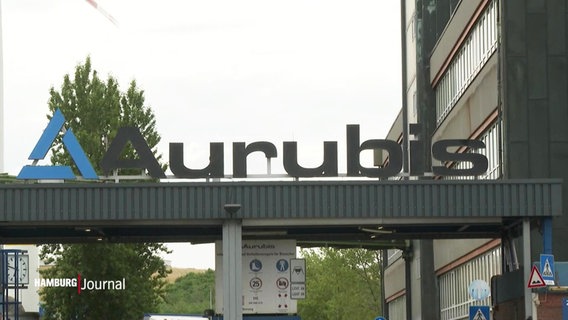Über einer Zufahrt zu einem Firmengelände prangert der Name "Aurubis". © Screenshot 