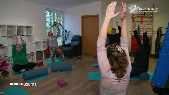 Mehrere Personen nehmen an einer inklusiven Yogastunde teil. © Screenshot 