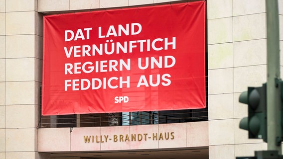 Ein erfundenes Plakat am Willy-Brandt-Haus: Dat Land vernünftich regieren un feddich aus (extra 3 vom 13.12.2023 im NDR Fernsehen) © NDR 