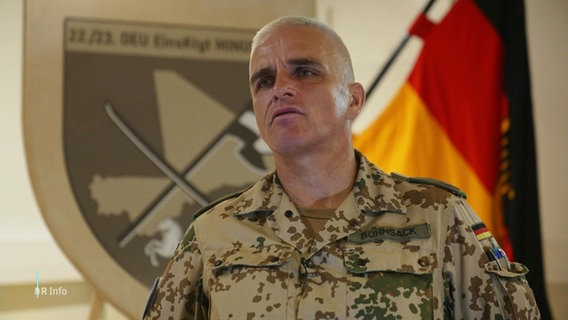 Heiko Bohnsack, Oberst bei der Bundeswehr, in Tarnkleidung. Im Hintergrund eine deutsche Nationalflagge. © Screenshot 