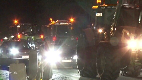 Eine Schlange von Traktoren neben Autos auf einer Straße. © Screenshot 