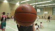 Ein Basketball vor einer Sporthalle. © Screenshot 