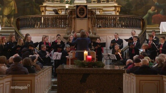 In einer Kirche singen junge Menschen in einem Chor bei einem Konzert. © Screenshot 