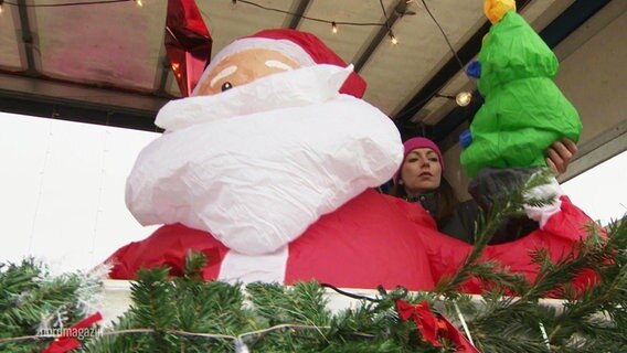 Aufblasbarer Weihnachtsmann begleitet den fahrenden Musikwagen von Bentwisch. © Screenshot 