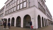 Menschen stehen vor dem ehemaligen Kaufhof in Neubrandenburg. © Screenshot 
