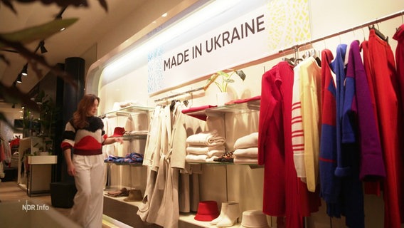 Kleidung in einem Modegeschäft, an der Wand der Schriftzug: "Made in Ukraine". © Screenshot 