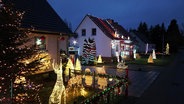 Zwei Häuser mit sehr viel Weihnachtsbeleuchtung. © Screenshot 