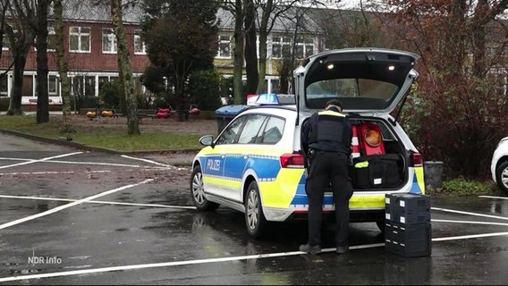 Ein Polizeiwagen steht vor einer Schule. © Screenshot 