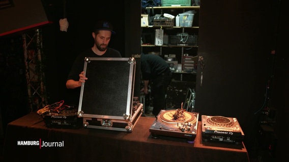 Jemand baut ein DJ-pult auf. © Screenshot 