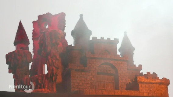 Ein Märchenschloss mit vielen Zinnen liegt im Nebel. © Screenshot 