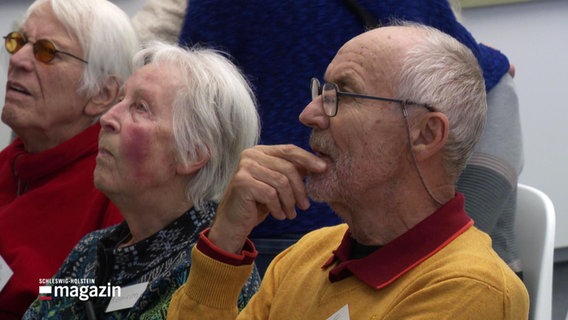 Drei ältere Personen betrachten eine Kunstwerk. © Screenshot 