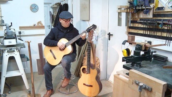 Lutz Splettstößer spielt auf einer selbstgebauten Gitarre. © Screenshot 