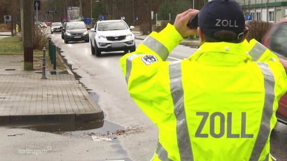 Ein Zollbeamter beobachtet vorbeifahrende Fahrzeuge. © Screenshot 