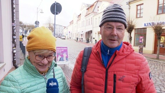 Zwei Menschen in bunten Jacken werden interviewt. © Screenshot 