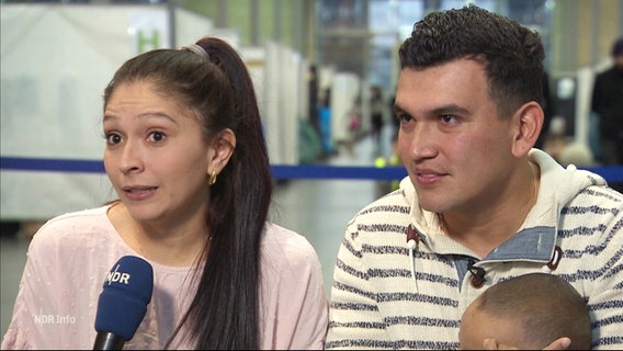 Angie Rodrígez Florez und ihr Mann Gerson Núñez Valderrama aus Kolumbien. Der Mann hält ein Baby auf dem Arm. © Screenshot 