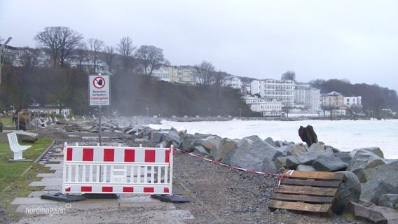 Eine Absperrung sperrt den Zutritt zu der zerstörten Küstenpromenade von Sassnitz. © Screenshot 