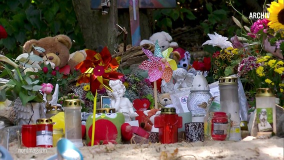Blumen, Kuscheltiere, Grabkerzen und Engel an einer Gedenkstätte für einen ermordetes Kind (Archivbild). © Screenshot 