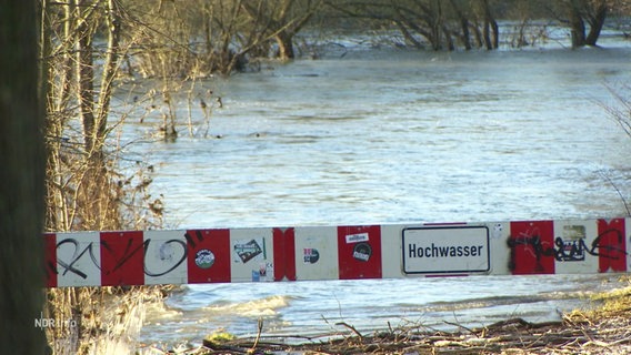 Eine Schranke sperrt einen überfluteten Weg. © Screenshot 