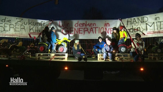 Kinder von Landwirten bei den Bauernprotesten unter einem Plakat mit der Aufschrift: "Wir denken in Generationen" © Screenshot 