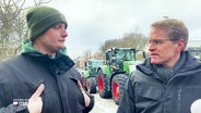 Ministerpräsident Daniel Günther von der CDU sucht das Gespräch mit einem demonstrierenden Landwirt. © Screenshot 