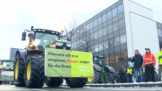 Ein Traktor mit einem Plakat mit der Aufschrift: "Niemand soll es je vergessen, Bauern sorgen für das Essen." © Screenshot 