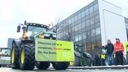 Ein Traktor mit einem Plakat mit der Aufschrift: "Niemand soll es je vergessen, Bauern sorgen für das Essen." © Screenshot 