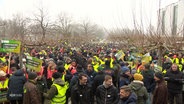 Sehr viele Landwirte auf einem großen Platz, viele von ihnen in gelben Westen. © Screenshot 