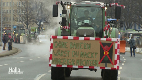 Ein Traktor mit einem Schild mit der Aufschrift: "Ohne Bauern wärst du nackt, hungrig und nüchtern." © Screenshot 
