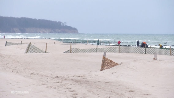 Mit Sand überspülte Abtrennungen in Warnemünde. © Screenshot 