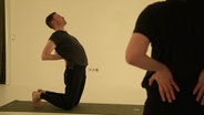Männer in einer Yoga-Pose © Screenshot 