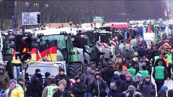Demonstrierende Bauern und Trecker auf einer großen Straße. © Screenshot 