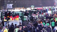 Demonstrierende Bauern und Trecker auf einer großen Straße. © Screenshot 