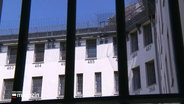 Ein Blick durch ein vergittertes Fenster der Justizvollzugsanstalt Neumünster. © Screenshot 
