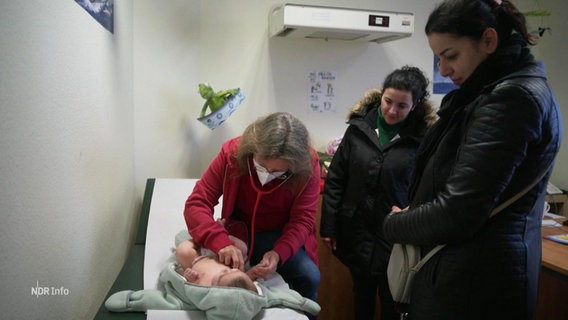 Eine Ärztin untersucht einen Säugling. © Screenshot 