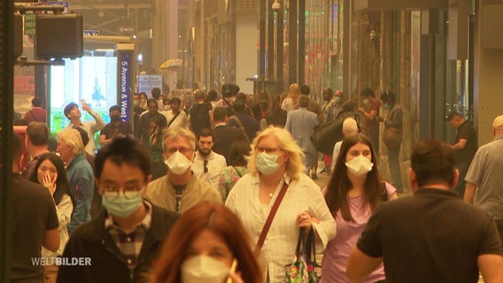 Passanten in New York tragen einen Atemschutz. © Screenshot 