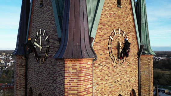 Fassadenkletterer überprüfen die Zifferblätter am Schleswiger Dom. © Screenshot 