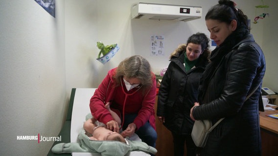 Eine Ärztin untersucht einen Säugling. © Screenshot 