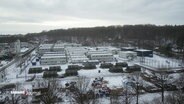 Vogelperspektive: Eine Unterkunft für geflüchtete Menschen in Hamburg. Im Vordergrund dunkelgrüne Zelte des Bundeswehr, dahinter Reihen mit Wohncontainern. © Screenshot 