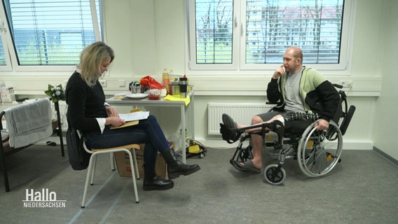 Zwei Personen in einem Raum. Eine sitzt im Rollstuhl. © Screenshot 