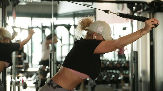 Eine Frau trainiert an einem Fitness-Gerät. © Screenshot 
