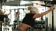 Eine Frau trainiert an einem Fitness-Gerät. © Screenshot 