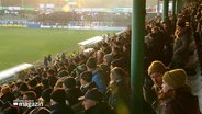 Eine Tribüne voller Fans bei einem Fußballspiel. © Screenshot 