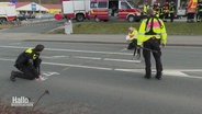 Polizeibeamte sichern Spuren eines Unfalls auf einer Straße. © Screenshot 