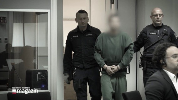 Eine Person in Handschellen wird in einen Gerichtssaal geführt. © Screenshot 