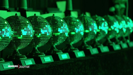 in grünes Licht getaucht: Diskokugeln als Preise in einer Reihe nebeneinander beim Clubaward in Hamburg. © Screenshot 