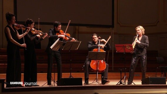 Drei Geigerinnen und Geiger, ein Cellist und eine Sopransaxophonistin auf der Bühne der Laeiszhalle. © Screenshot 